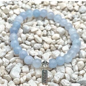 AURA Serenity Blue beaded bracelet with silver charm invokes a sense of charm